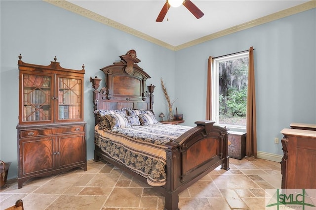 bedroom featuring ornamental molding, baseboards, stone tile floors, and a ceiling fan