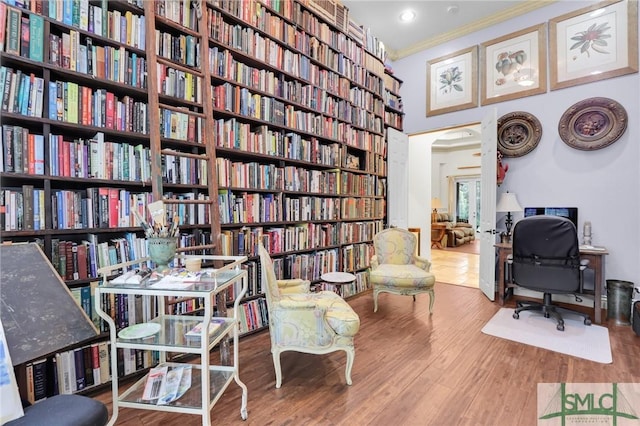 office space with bookshelves, wood finished floors, and crown molding