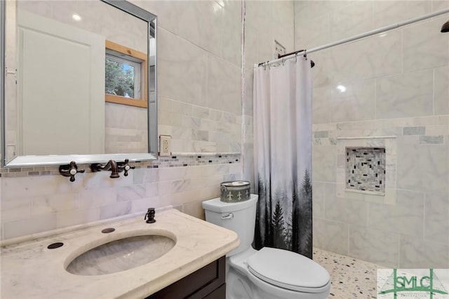 full bath featuring tiled shower, toilet, backsplash, vanity, and tile walls