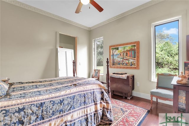 bedroom with baseboards, multiple windows, wood-type flooring, and crown molding