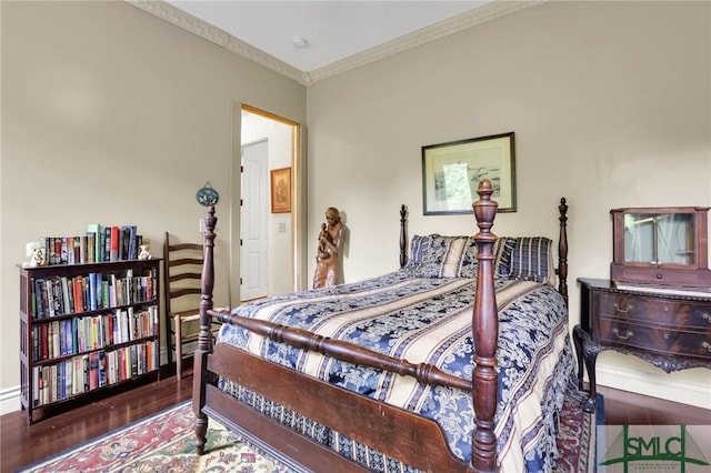 bedroom with crown molding and wood finished floors