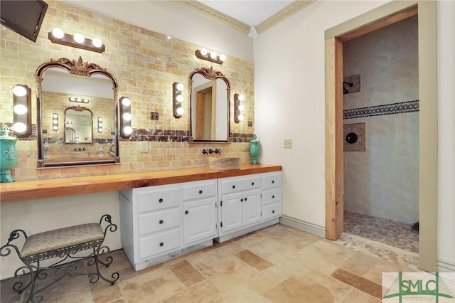 full bath with crown molding, vanity, decorative backsplash, and walk in shower