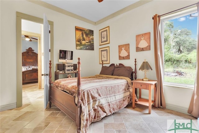 bedroom featuring baseboards and stone tile floors