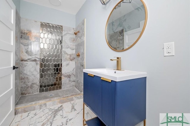 full bathroom featuring marble finish floor, tiled shower, and vanity