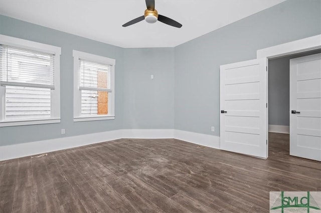 empty room featuring a ceiling fan, baseboards, and wood finished floors