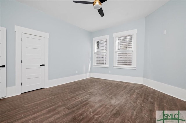 empty room with ceiling fan, dark wood-type flooring, and baseboards