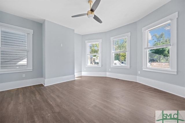 unfurnished room featuring dark wood finished floors, baseboards, and ceiling fan