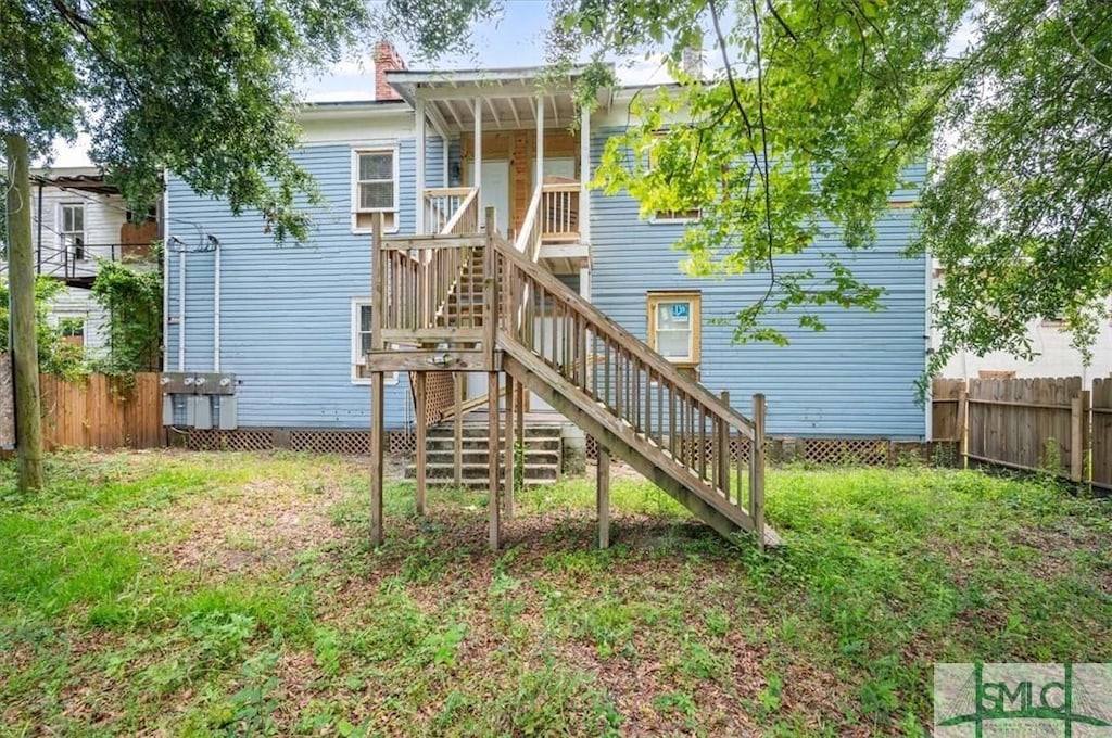 view of playground featuring fence, stairway, and a yard