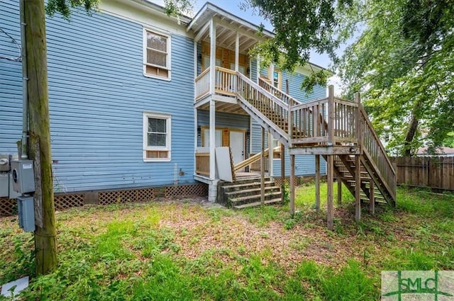 back of house featuring stairway and fence