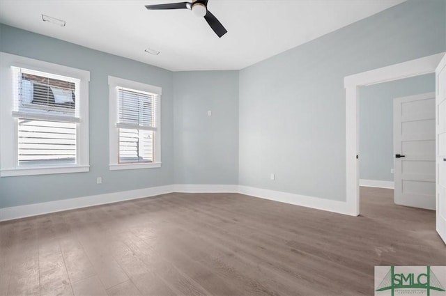 spare room with ceiling fan, wood finished floors, and baseboards