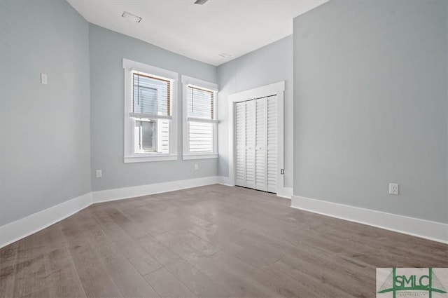 unfurnished room featuring baseboards and wood finished floors