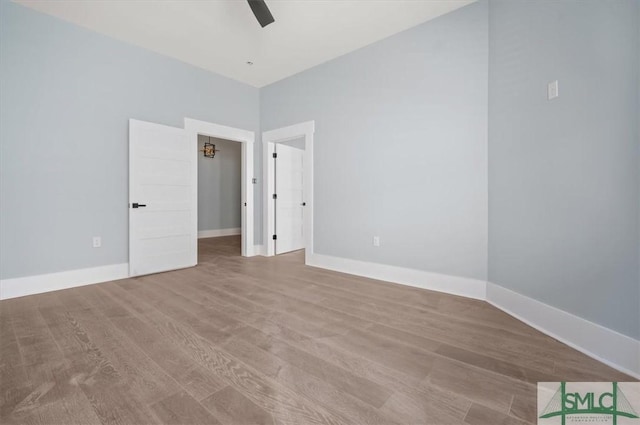 interior space with ceiling fan, baseboards, and wood finished floors