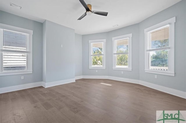 empty room with ceiling fan, baseboards, and wood finished floors