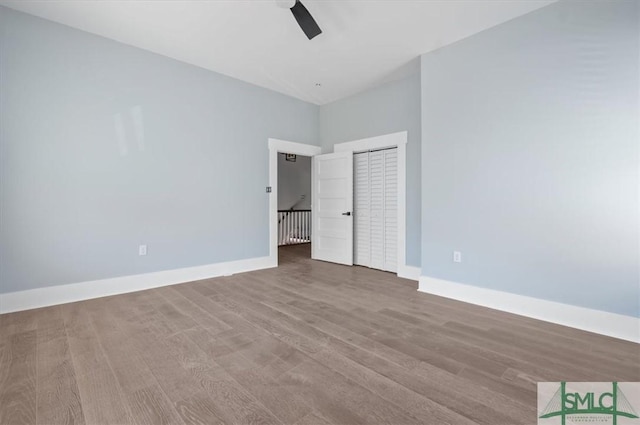 unfurnished bedroom with ceiling fan, wood finished floors, and baseboards