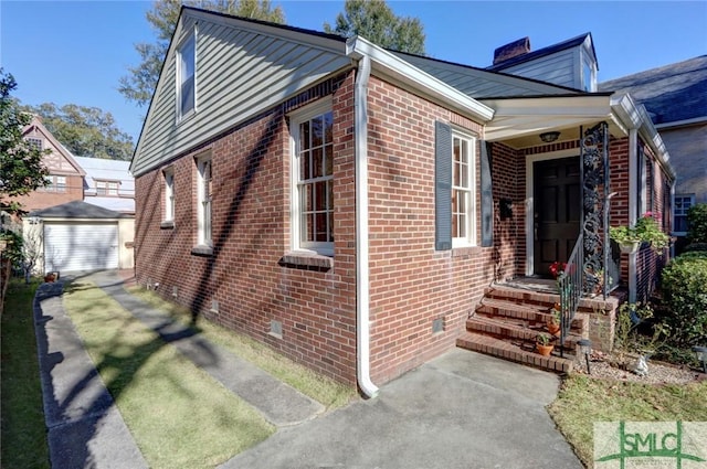 bungalow-style home featuring crawl space, an outdoor structure, and brick siding