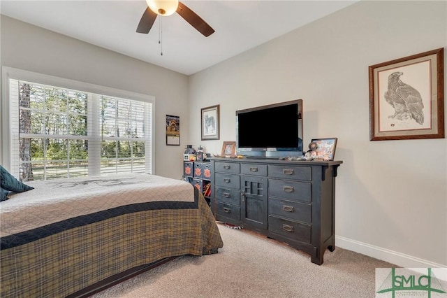 bedroom with a ceiling fan, light colored carpet, and baseboards