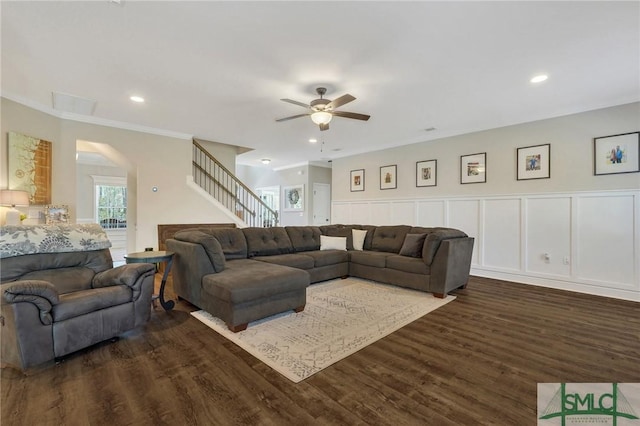 living area featuring recessed lighting, a decorative wall, dark wood-type flooring, a ceiling fan, and stairway