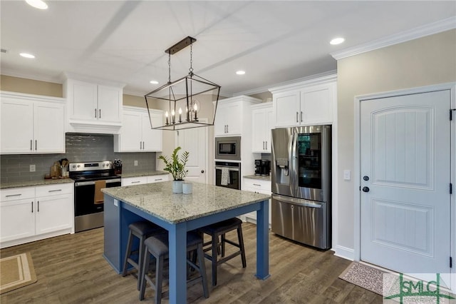 kitchen featuring a center island, dark wood-style flooring, crown molding, stainless steel appliances, and a kitchen bar