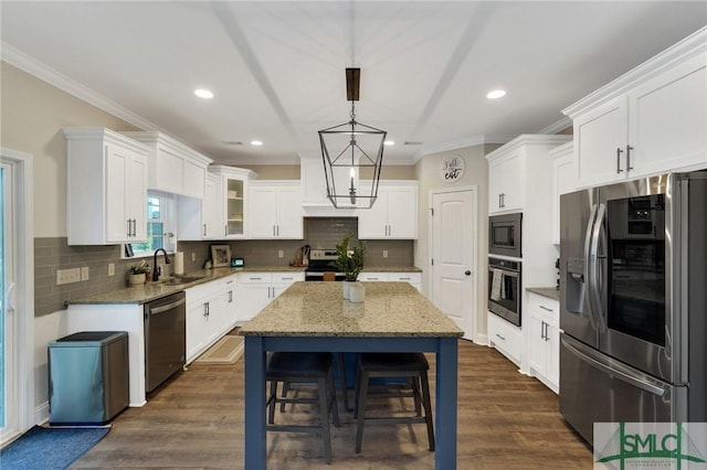 kitchen with a kitchen island, dark wood-style flooring, stainless steel appliances, and a sink