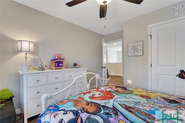 bedroom with ceiling fan and baseboards