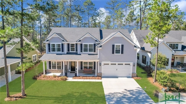 view of front of property with an attached garage, covered porch, driveway, and a front lawn