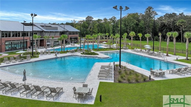 pool featuring a patio area, fence, and a yard