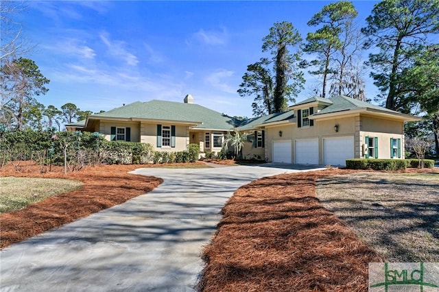 view of front facade with a garage, concrete driveway, roof mounted solar panels, and stucco siding