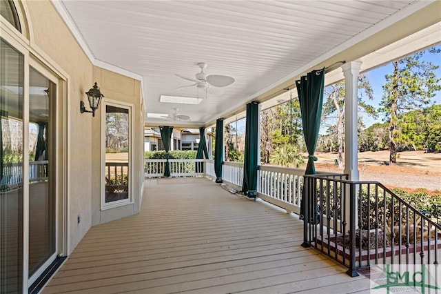 deck with covered porch and a ceiling fan