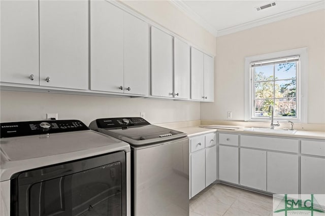 laundry area with cabinet space, visible vents, crown molding, washing machine and dryer, and a sink