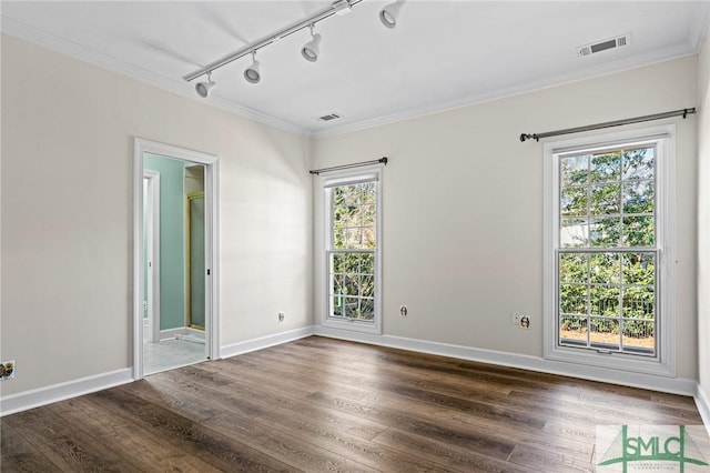 spare room with dark wood-style floors, visible vents, and crown molding