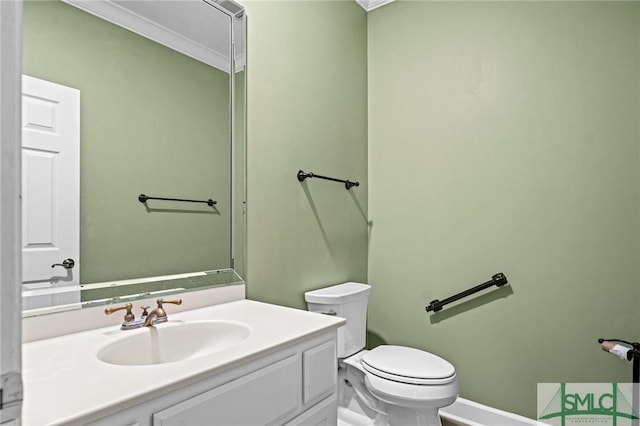 bathroom featuring toilet, ornamental molding, and vanity