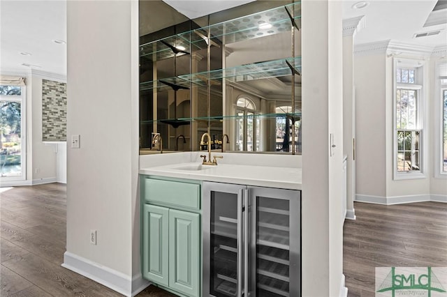 bar with visible vents, a sink, a wealth of natural light, and crown molding