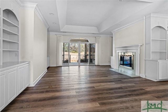 unfurnished living room with baseboards, a raised ceiling, dark wood-style flooring, and a high end fireplace