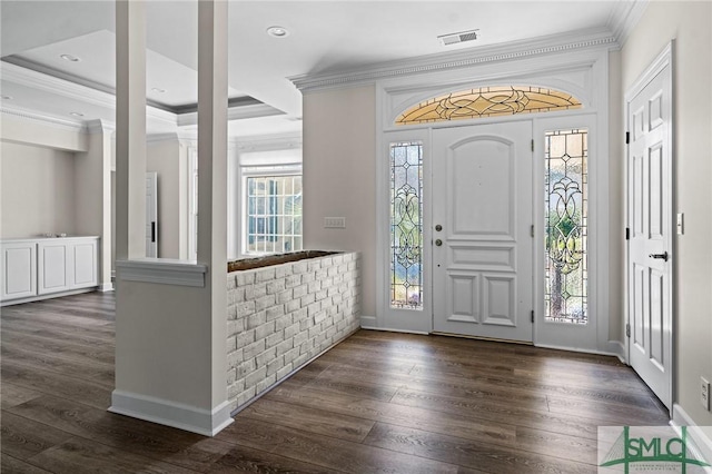 foyer featuring dark wood finished floors, visible vents, and crown molding