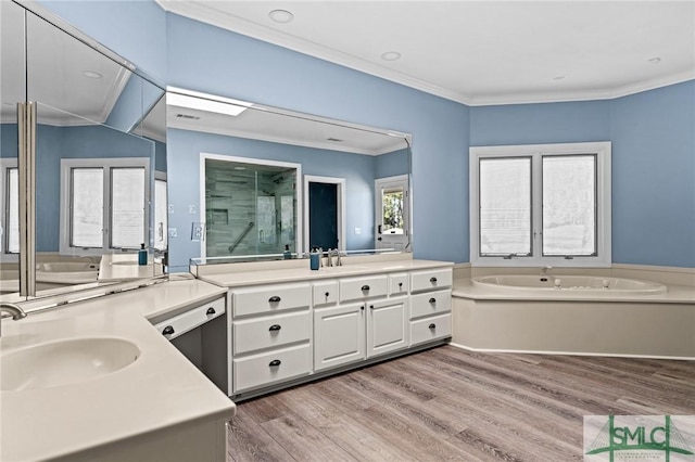 bathroom with wood finished floors, a sink, crown molding, a shower stall, and a bath