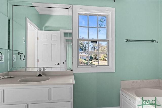 bathroom with a garden tub, vanity, and crown molding