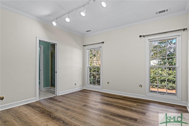 spare room featuring ornamental molding, visible vents, and wood finished floors