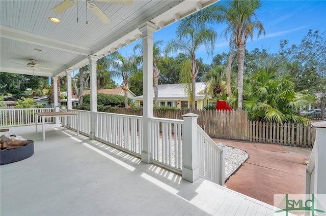 view of patio featuring a ceiling fan, fence, and a porch