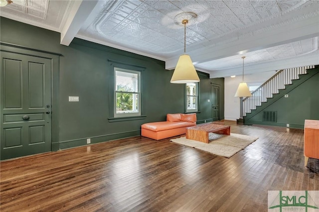 unfurnished living room featuring visible vents, baseboards, stairs, wood-type flooring, and crown molding