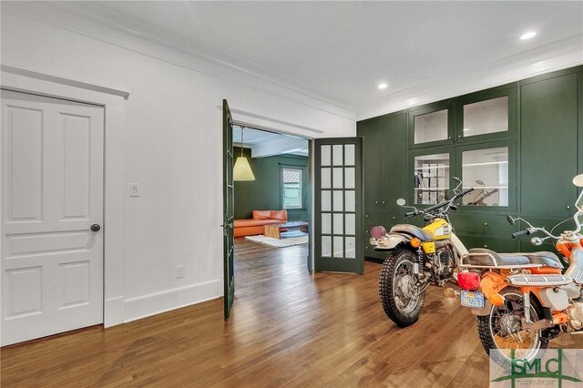 interior space with french doors, recessed lighting, ornamental molding, wood finished floors, and baseboards