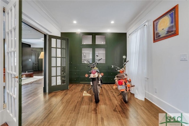 interior space with baseboards, wood finished floors, crown molding, french doors, and recessed lighting