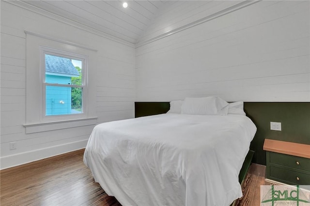 bedroom with lofted ceiling, dark wood-type flooring, and baseboards