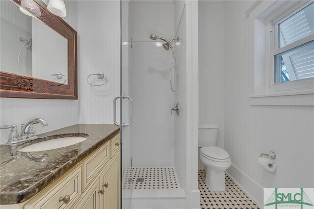 full bathroom with a stall shower, vanity, toilet, and tile patterned floors