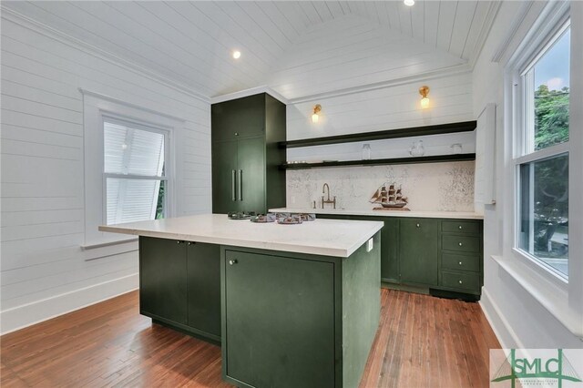 kitchen featuring lofted ceiling, a kitchen island, green cabinets, dark wood-style floors, and open shelves