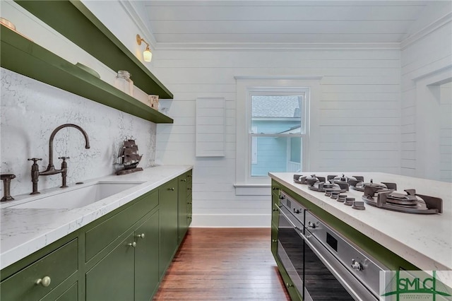 kitchen with dark wood finished floors, green cabinetry, a sink, and open shelves