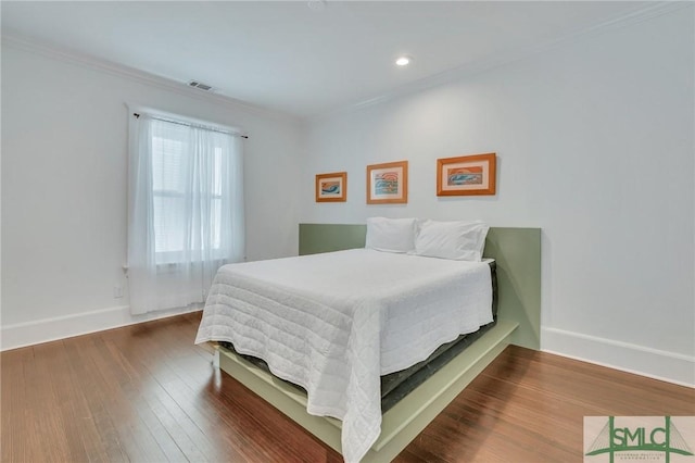 bedroom with ornamental molding, recessed lighting, wood finished floors, and baseboards