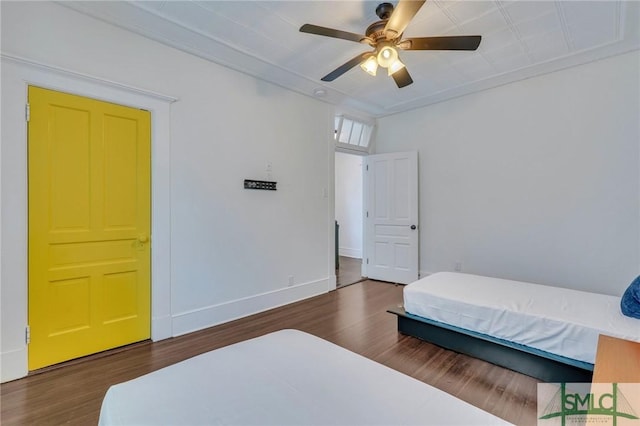 bedroom with a ceiling fan, baseboards, and wood finished floors