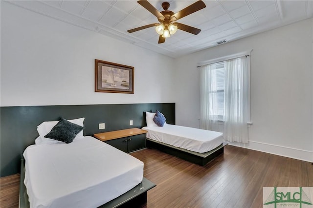 bedroom featuring visible vents, ceiling fan, baseboards, and wood finished floors
