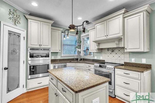 kitchen with stainless steel appliances, a sink, backsplash, and ornamental molding