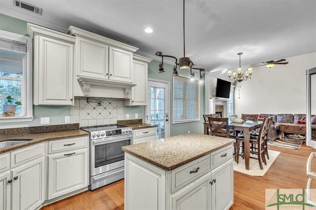 kitchen featuring visible vents, open floor plan, light wood-type flooring, stainless steel electric range, and backsplash